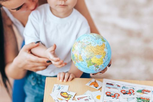 child with globe and teacher image